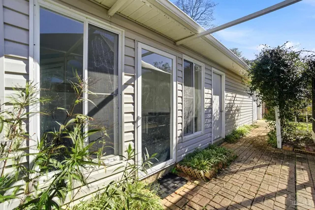a view of a house with a large window and potted plants