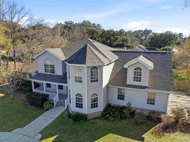 an aerial view of a house with large trees
