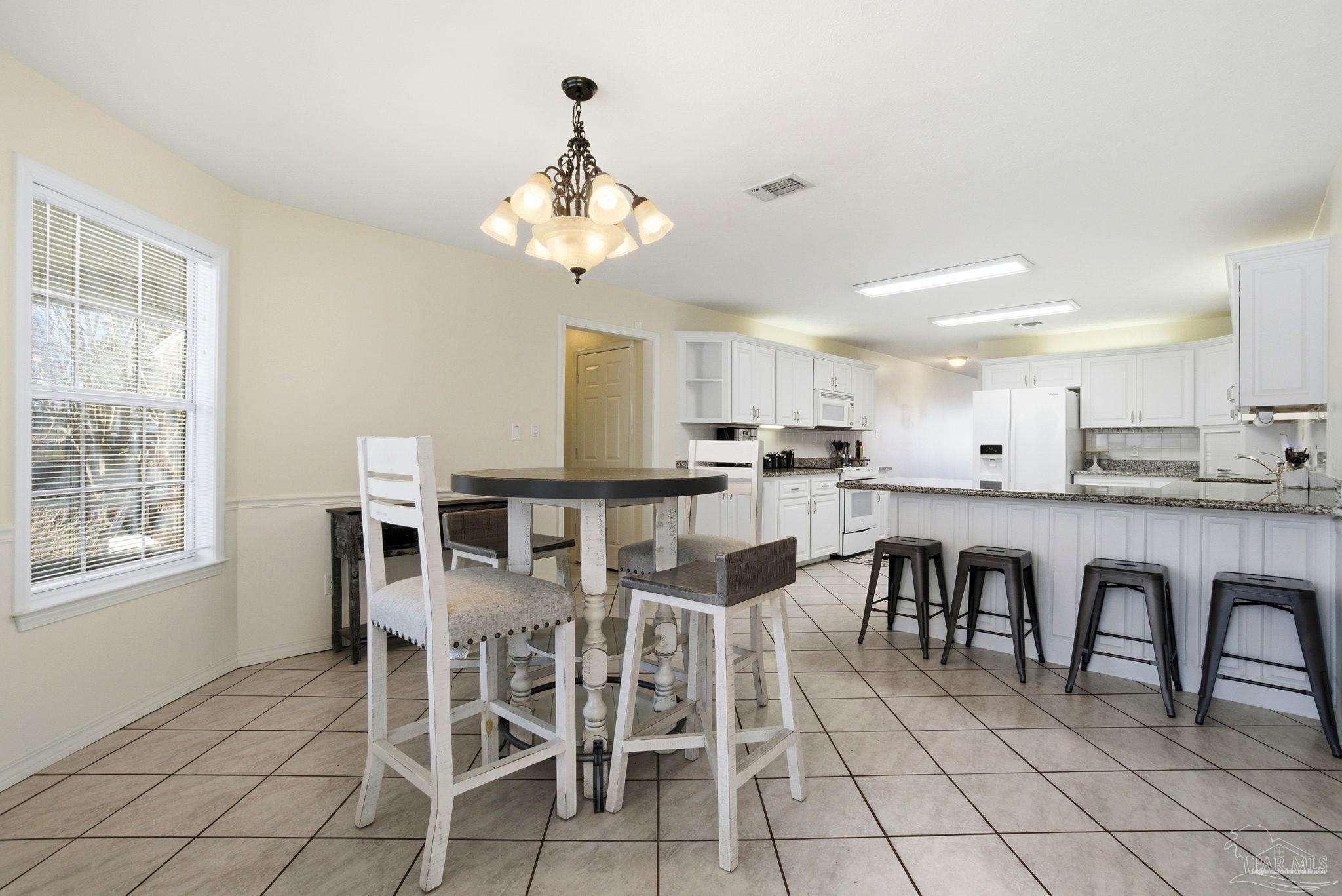 1805 West 10 Mile Road Pensacola, FL 32534 - Photo 7 of 61 a view of a dining room with furniture and chandelier