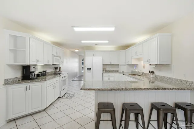 a kitchen with sink cabinets and dining table chair
