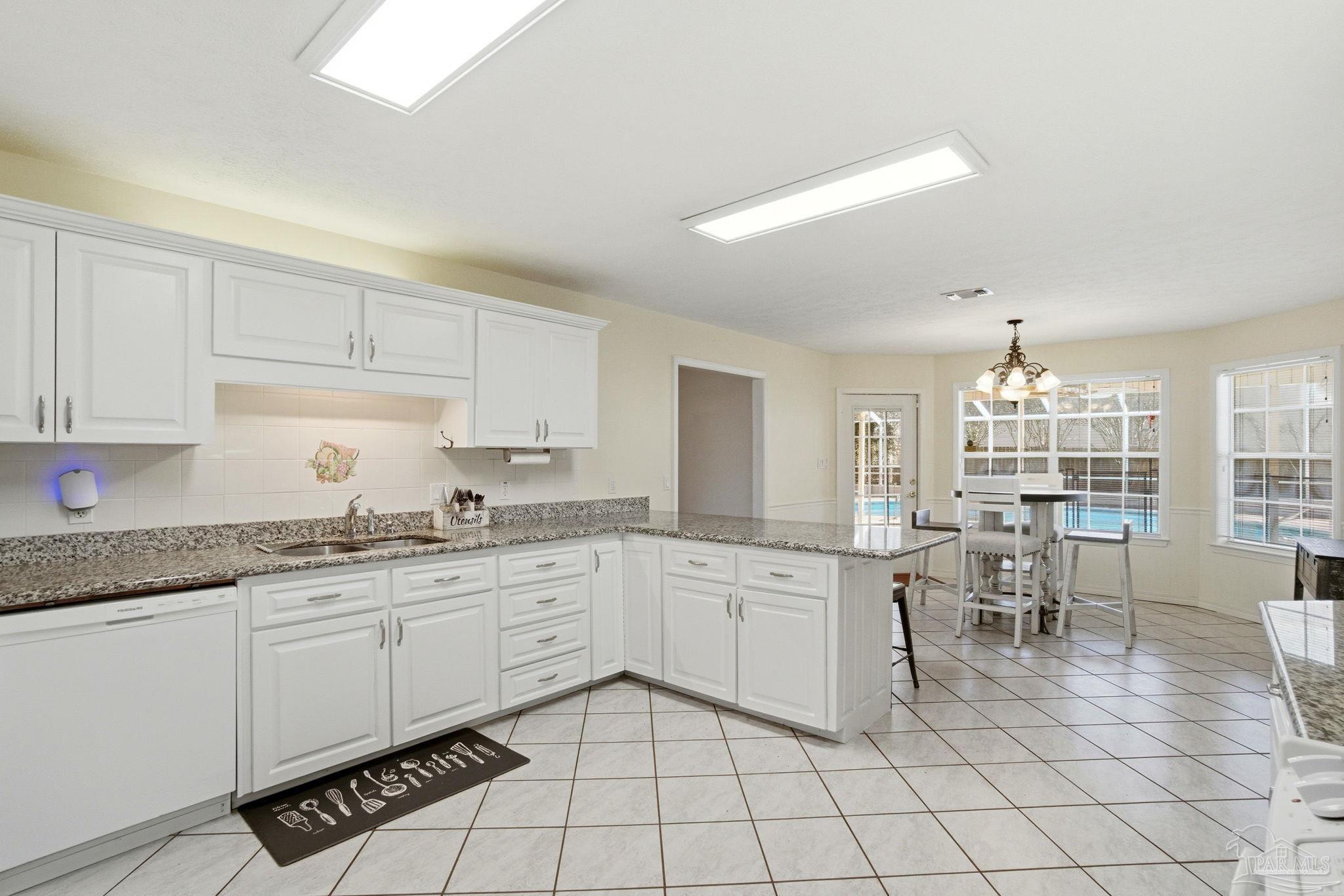 1805 West 10 Mile Road Pensacola, FL 32534 - Photo 9 of 61 a kitchen with sink cabinets and dining table chair
