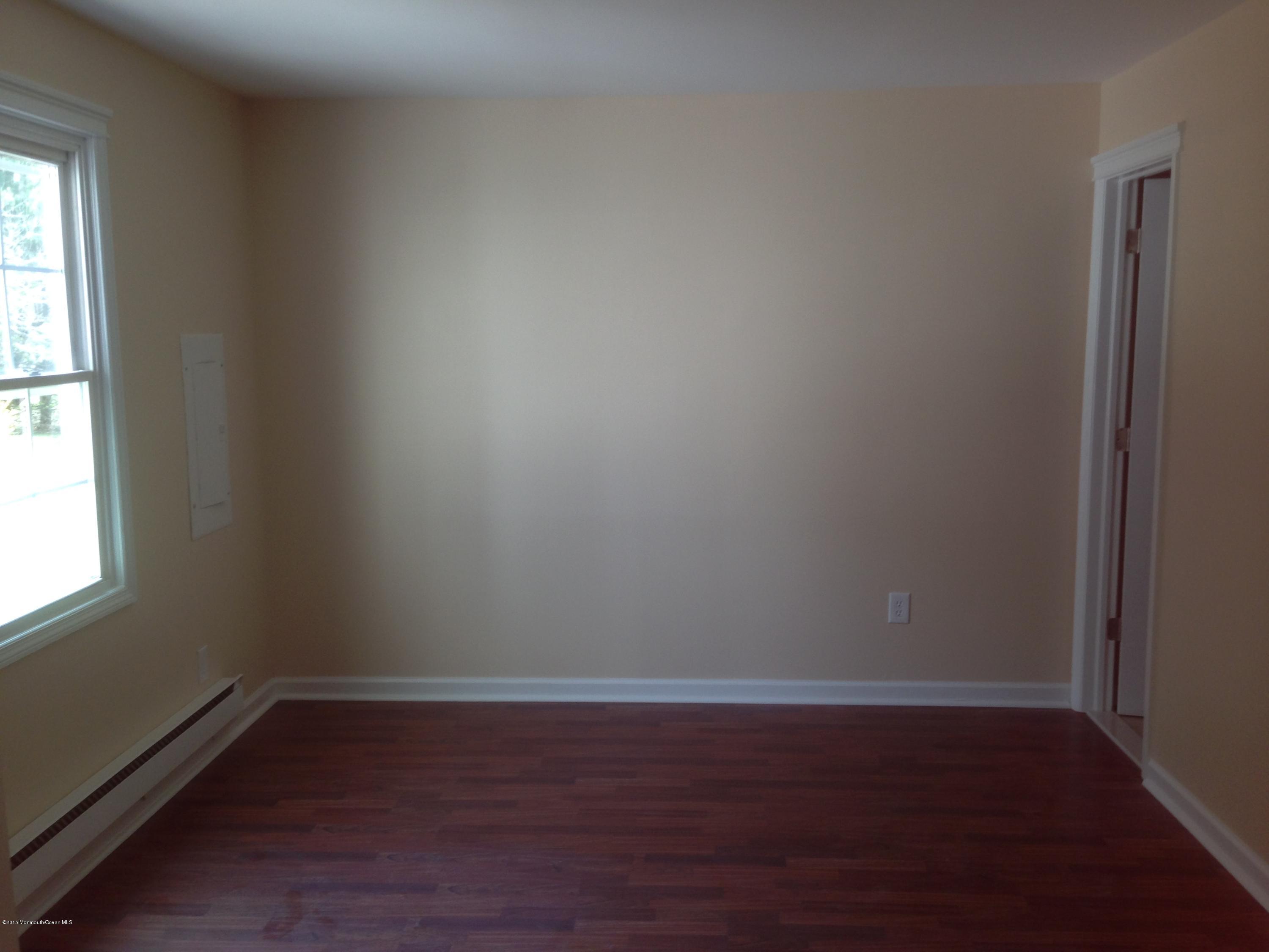 94 Halls Croft Road, Unit B Freehold, NJ 07728 - Photo 7 of 12 a view of an empty room with wooden floor and a window