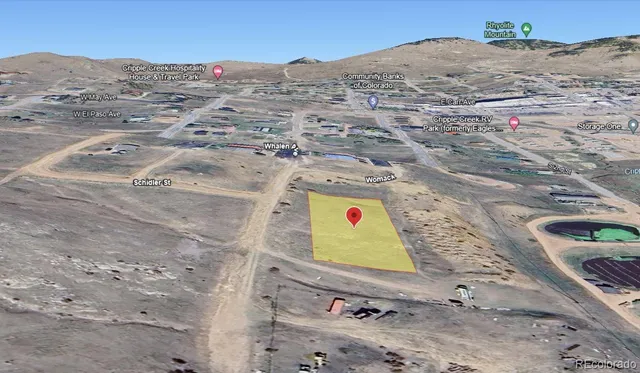 a view of a dry field with mountains in the background