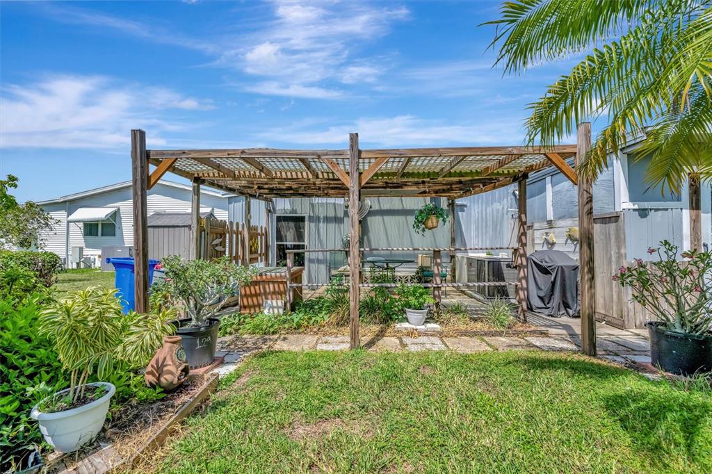 124 St Pierres Way Apollo Beach, FL 33572 - Photo 49 of 56 a view of a patio with table and chairs potted plants and palm trees