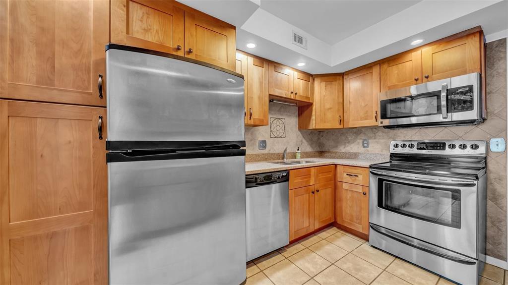 17400 Gulf Boulevard, Unit J7 Redington Shores, FL 33708 - Photo 16 of 32 a kitchen with granite countertop a refrigerator and a stove