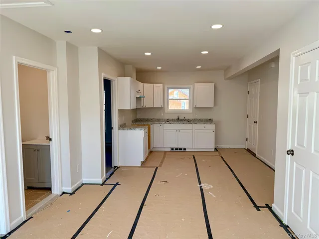 a kitchen with granite countertop a sink a stove and cabinets
