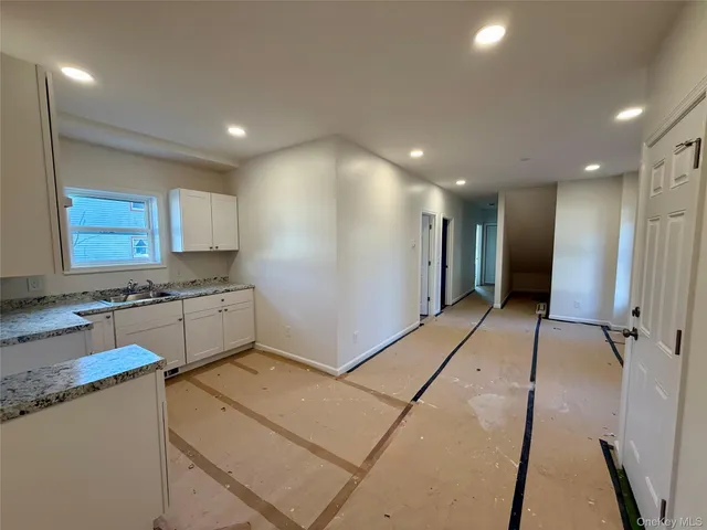 a kitchen with granite countertop white cabinets and white appliances