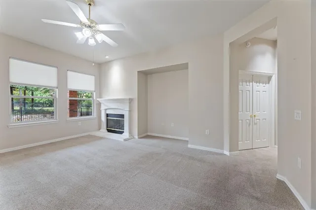 an empty room with windows and fireplace