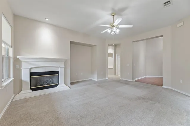 an empty room with fireplace and fan