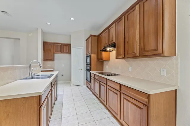 a kitchen with stainless steel appliances granite countertop a sink stove and cabinets