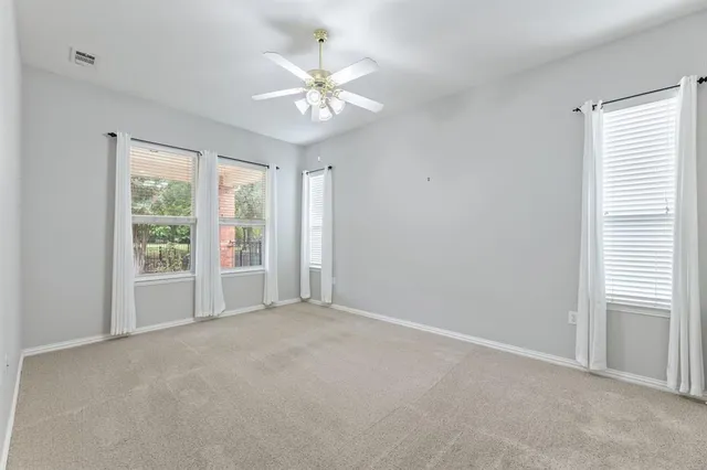 a spacious bedroom with a bed and a chandelier