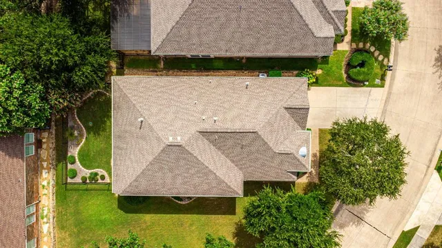 an aerial view of residential houses with outdoor space and trees