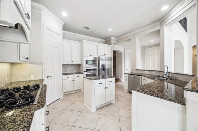 a kitchen with stainless steel appliances granite countertop a sink stove and refrigerator