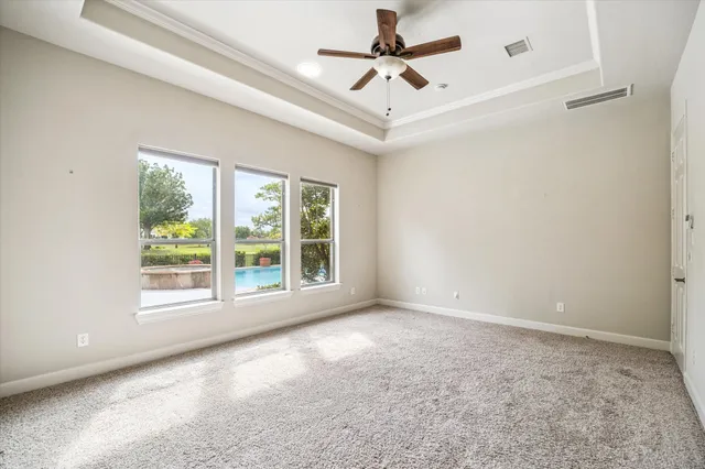 a large white kitchen with a stove a sink a window and dining table