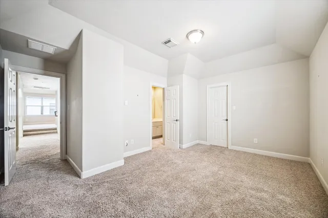 an empty room with closet and a bathroom