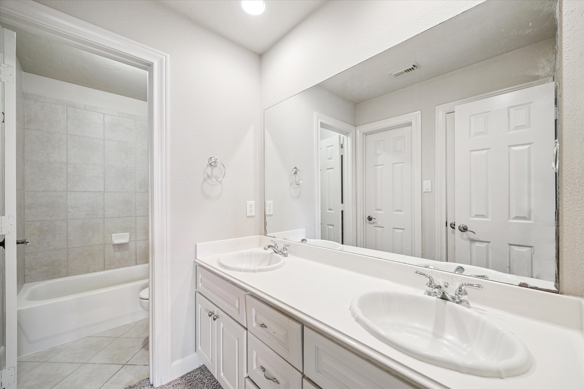 3327 Louvre Lane Houston, TX 77082 - Photo 25 of 31 a bathroom with a double vanity sink large mirror and a bathtub