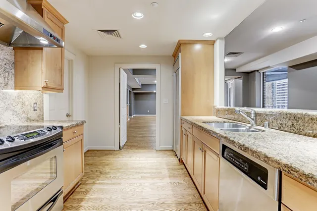a kitchen with stainless steel appliances granite countertop a stove and a sink