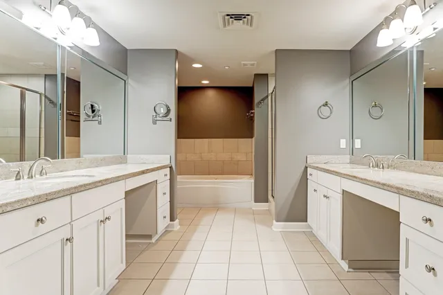 a spacious bathroom with a granite countertop sink a toilet a mirror and a bathtub