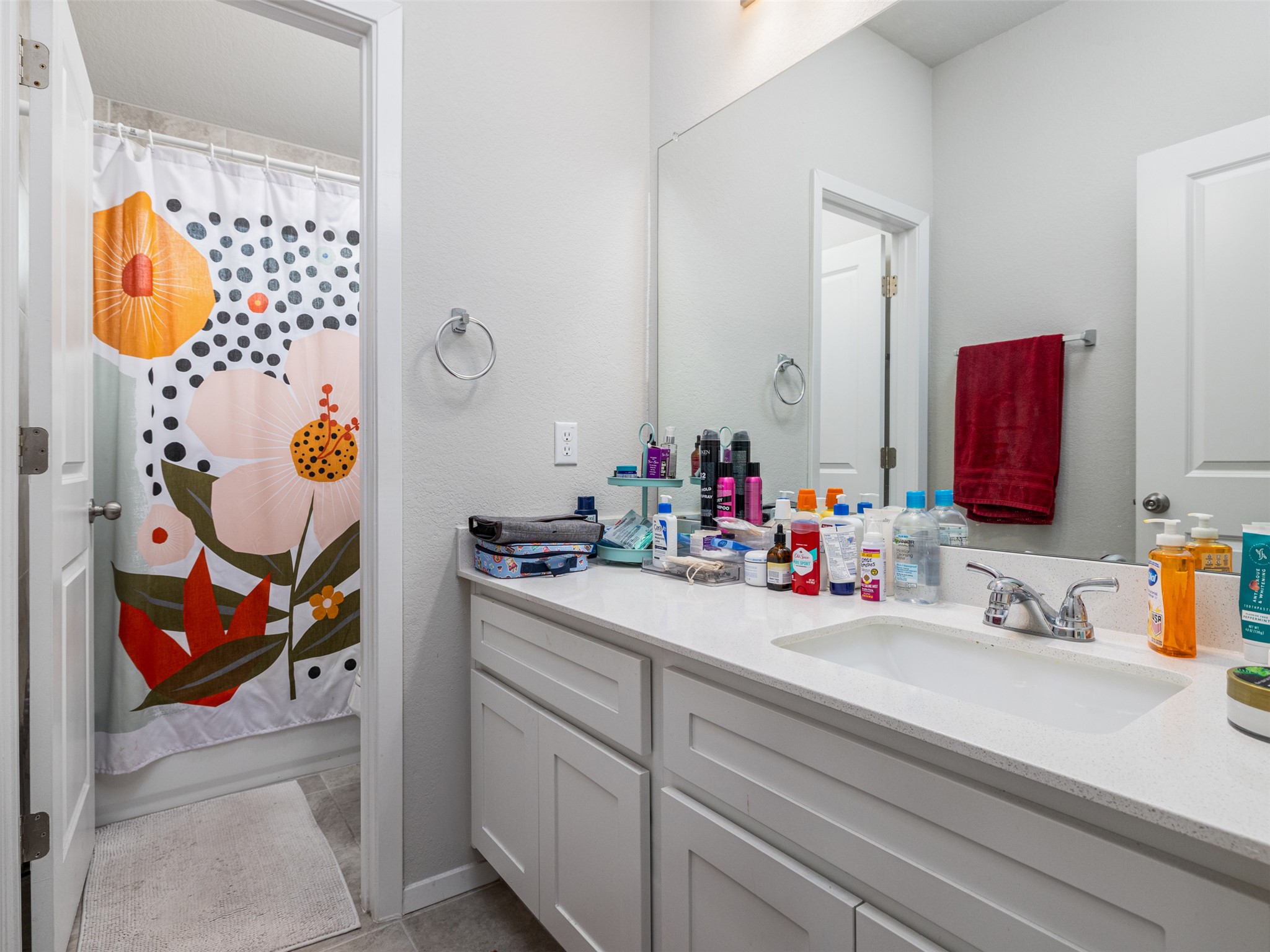 121 Graver Street Georgetown, TX 78626 - Photo 16 of 28 White cabinetry provides ample storage beneath a solid surface vanity with an integrated sink.