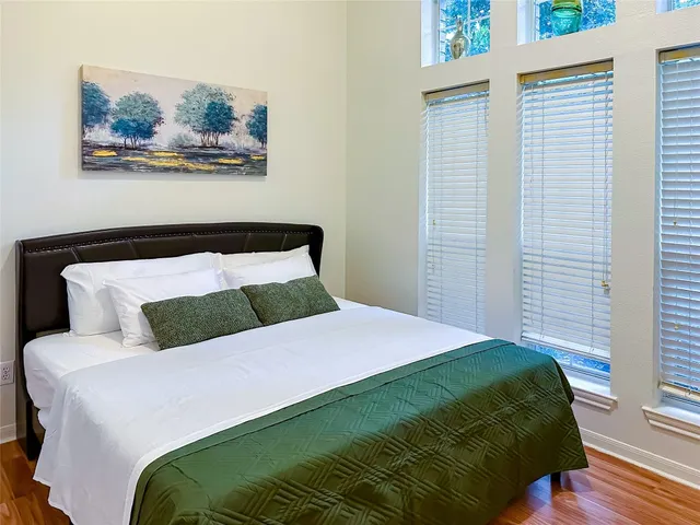 a bedroom with a bed and painting on the wall