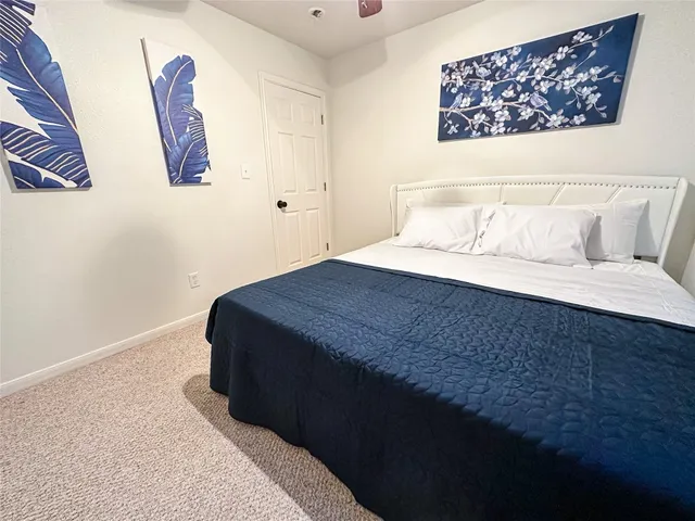 a bedroom with a bed and painting on the wall