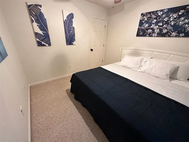 a bedroom with a bed and painting on the wall