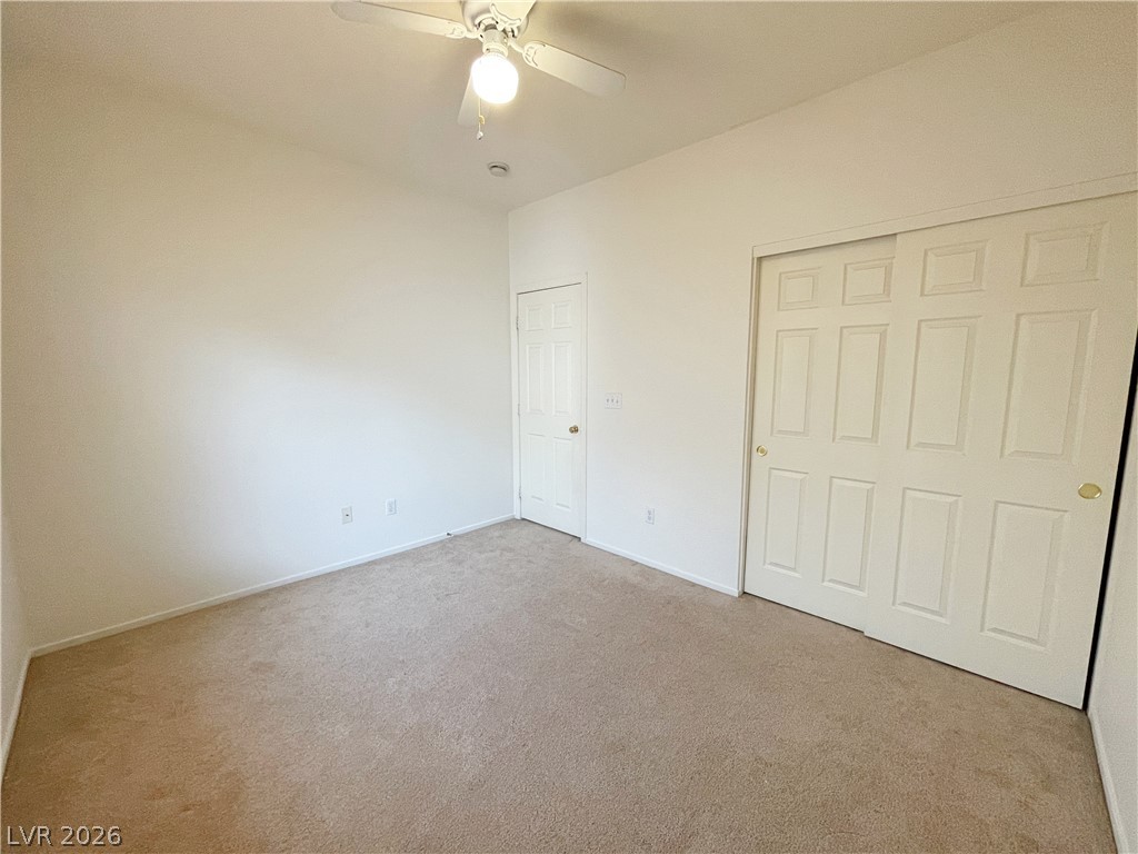 691 Principle Point Avenue Henderson, NV 89012 - Photo 27 of 30 A well-lit bedroom offering a blank canvas for personalization, complete with soft carpet and a convenient sliding closet door.