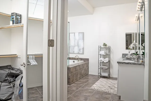 a bathroom with a tub sink and mirror