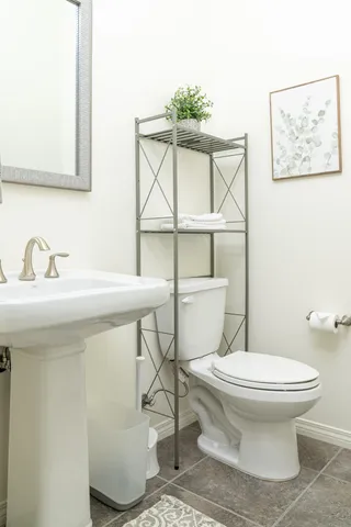 a bathroom with a toilet sink and mirror