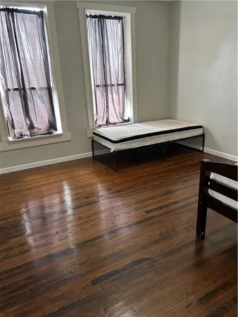 a view of an empty room with wooden floor and stairs