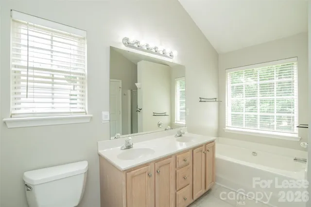 a bathroom with a tub a sink and a large mirror