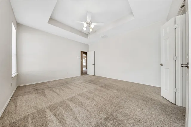 a view of an empty room with a chandelier fan