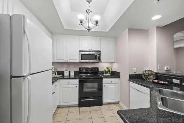 a kitchen with granite countertop a sink and a stove in it
