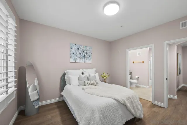 a bathroom with a granite countertop sink toilet and mirror