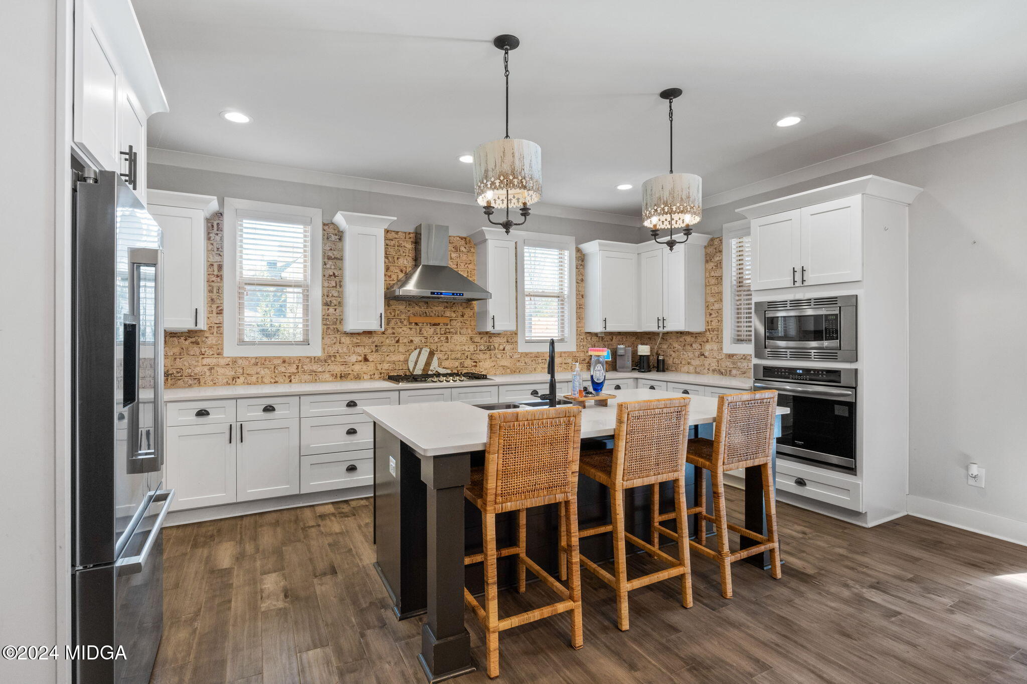 131 Belmont Way Forsyth, GA 31029 - Photo 17 of 68 a kitchen with stainless steel appliances kitchen island granite countertop a table chairs and white cabinets