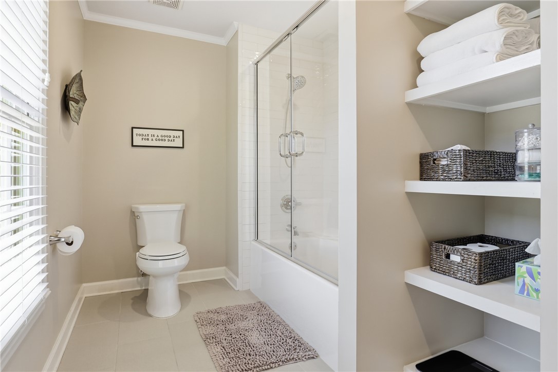 103 5 Knoll Court Anderson, SC 29621 - Photo 20 of 33 A well-appointed bath offers convenient open shelving and a glass-enclosed shower over the tub.