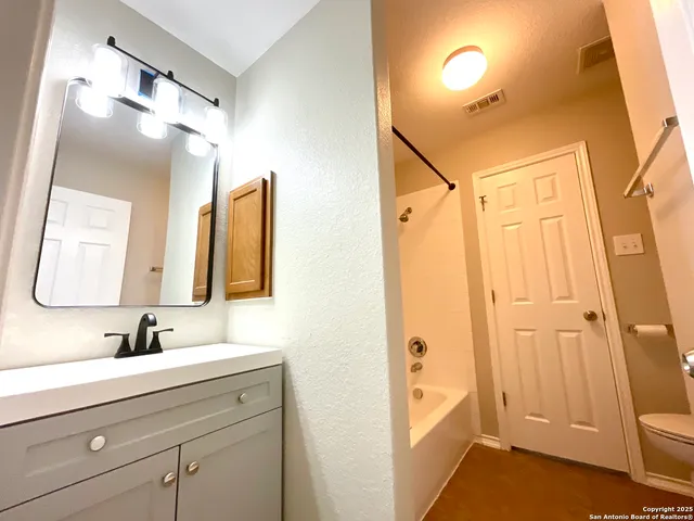 a bathroom with a shower sink and mirror