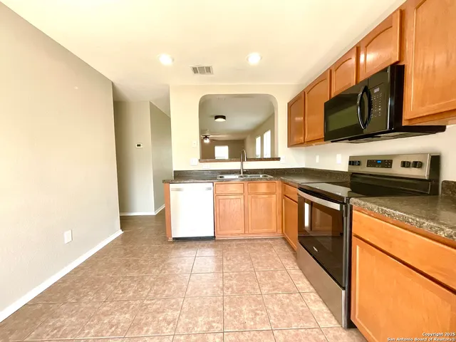 a kitchen with stainless steel appliances granite countertop a sink and a stove