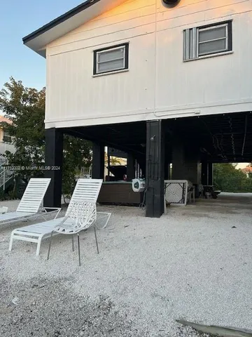 a view of a patio with table and chairs near a barbeque