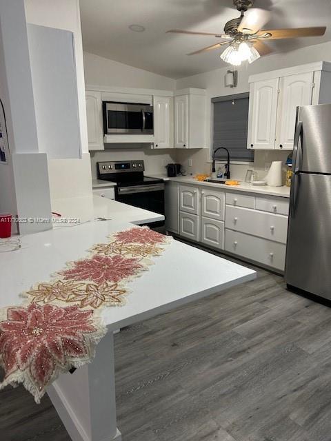 74 Pelican Lane, Unit 1 Big Pine Key, FL 33043 - Photo 3 of 23 a kitchen with kitchen island granite countertop a stove top oven a refrigerator a sink and dishwasher with wooden floor