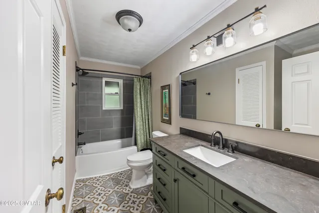 a bathroom with a granite countertop sink a toilet a mirror and bathtub