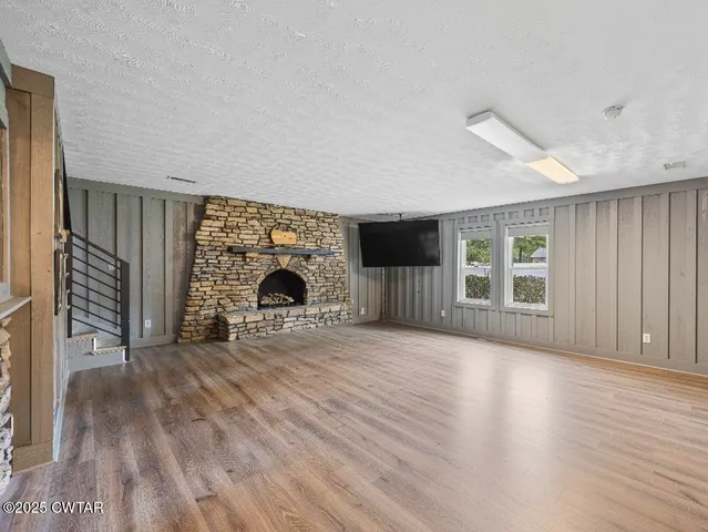 wooden floor fireplace and windows in an empty room