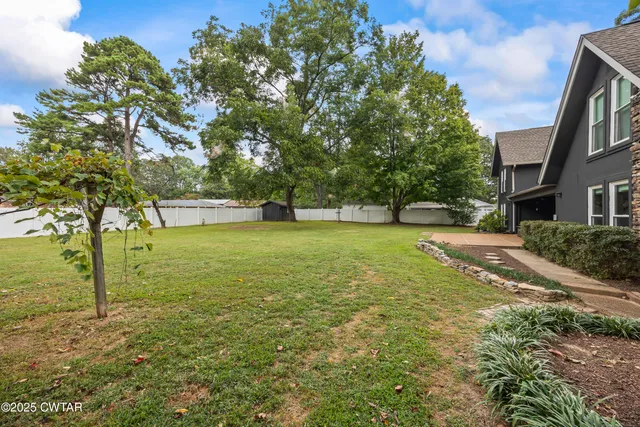 a view of a trees with yard in front of it