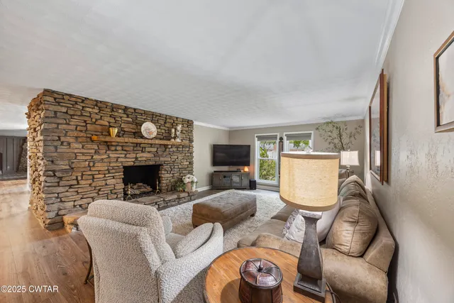 a living room with furniture a fireplace and a flat screen tv