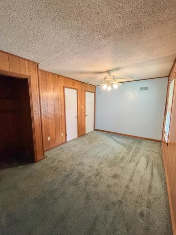 a view of an empty room with chandelier and window