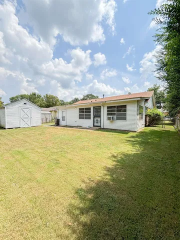 a view of a house with backyard and sitting area