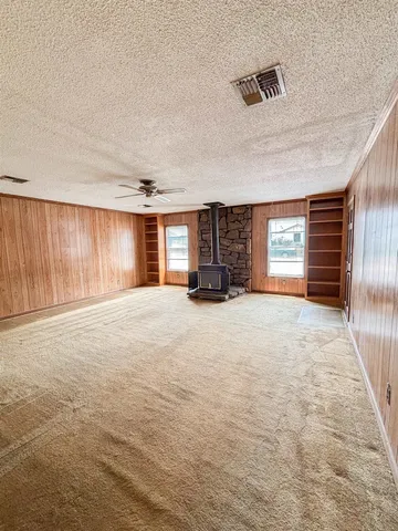 a view of empty room with a fireplace and window