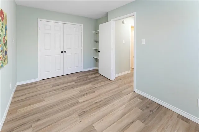 an empty room with wooden floor and white wall