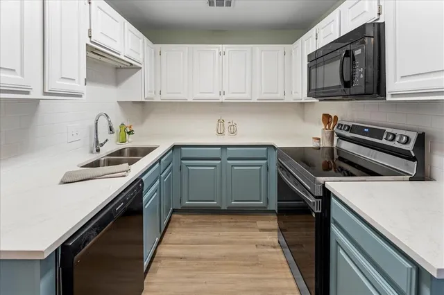 a kitchen with a sink stove top oven and cabinets