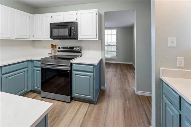 a kitchen with stainless steel appliances a stove a microwave a sink and cabinets